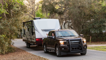 family arriving with their travel trailer at a campsite