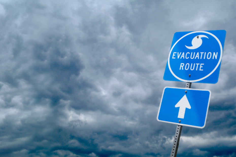 evacuation route sign in front of dark clouds with hurricane coming