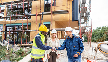 construction manager shaking hands - excess liability vs commercial umbrella