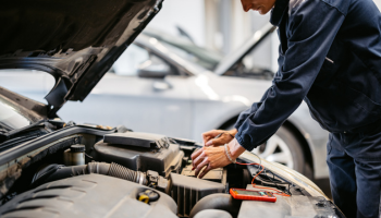 Car mechanic working on car battery