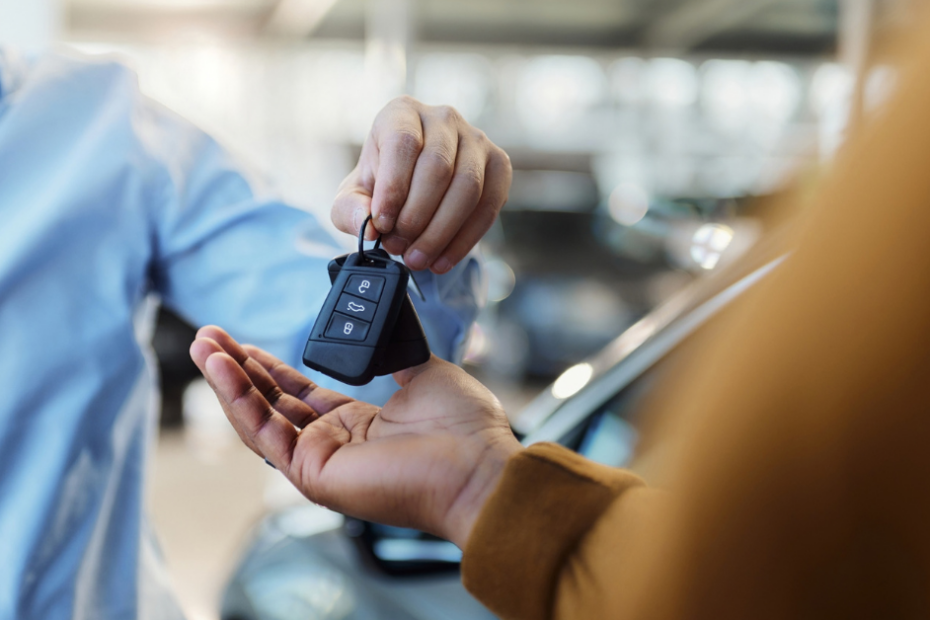 a person handing over car keys to a rental