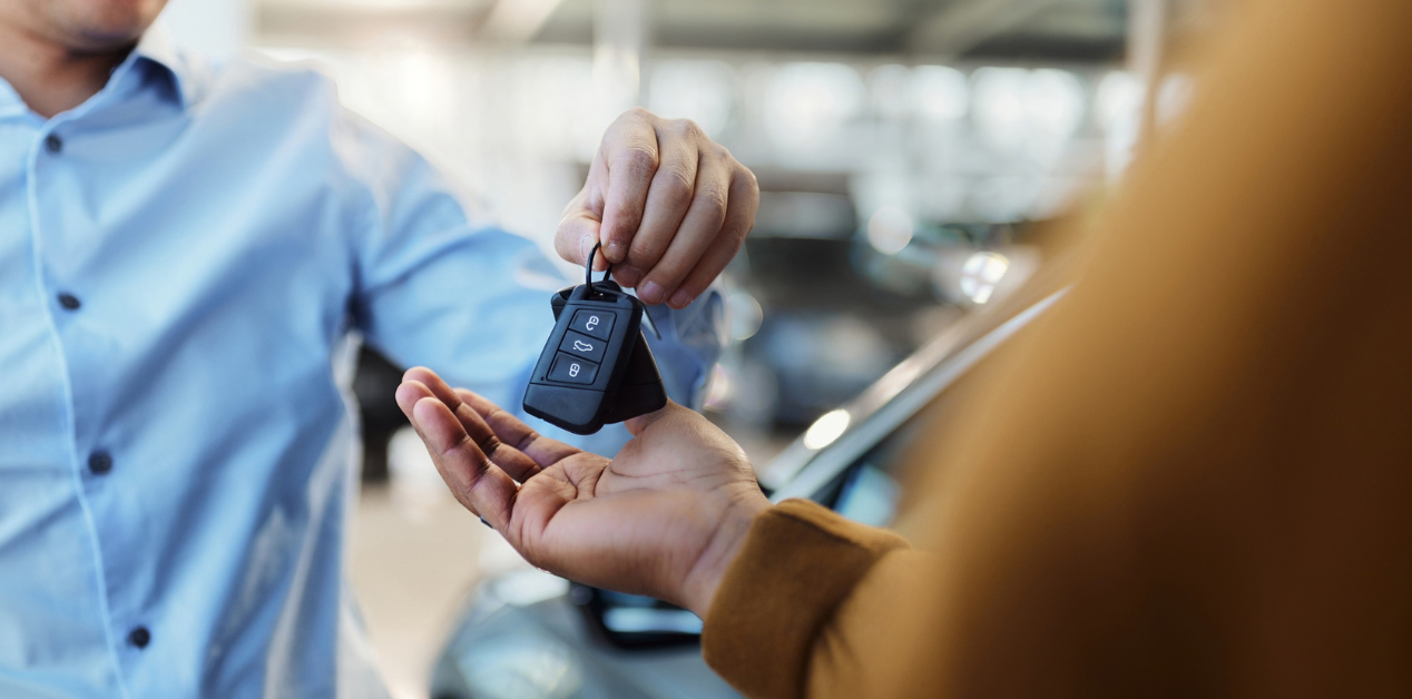 a person handing over car keys to a rental