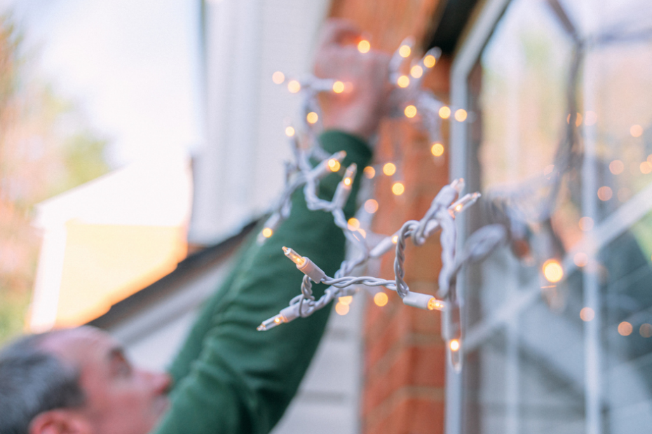 adult setting up holiday decorations