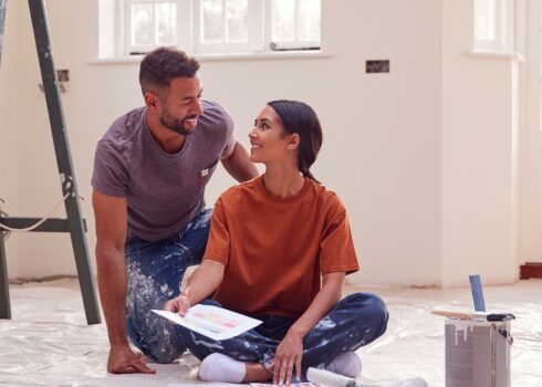 Couple sitting on the floor ready for a new home improvement project